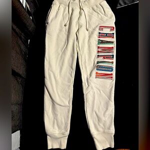 Champion cream joggers with multicolored logo, elastic cuffs, drawstring waist.